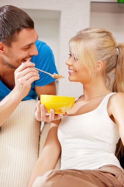 foto brilhante de casal feliz com muesli (foco no homem)