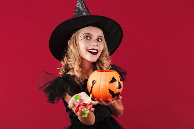 Foto de bruja niña malvada positiva en disfraz de halloween de carnaval