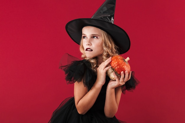 Foto foto de bruja niña seria en disfraz de halloween de carnaval