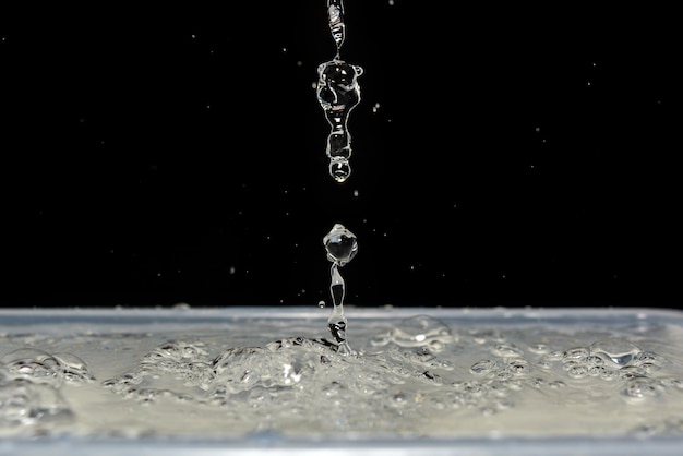 Foto de buen goteo de agua y gotas en fondo negro