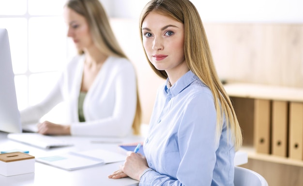 Foto de cabeza de mujer de negocios. Empresarios o colegas discutiendo algo en la reunión mientras están sentados en el escritorio de la oficina. Estilo de ropa informal. Concepto de auditoría, impuestos o abogado.