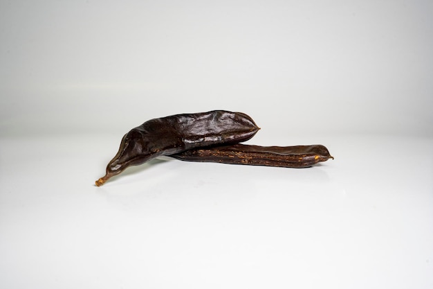 Foto de cacao vegetariano con algarroba aislado sobre fondo blanco.