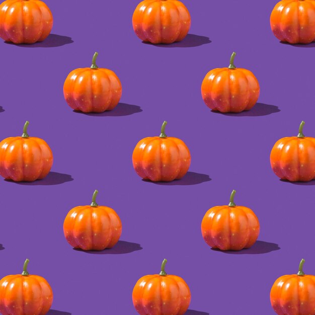 Foto de calabazas naranjas sobre fondo violeta aislado