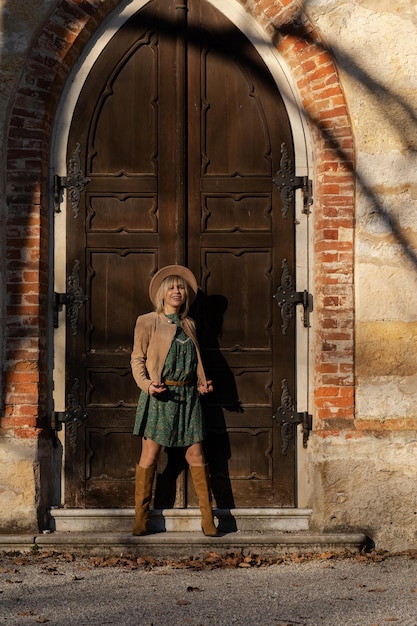 Foto de una chica al estilo boho en el fondo de la puerta de la capilla de la Edad Media