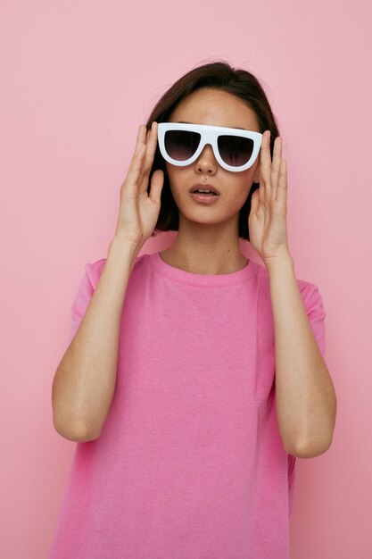 Foto chica guapa en una camiseta rosa gafas de sol de moda fondo aislado