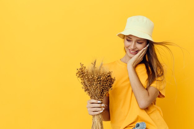 Foto chica guapa en camisetas amarillas flores secas en manos fondo aislado