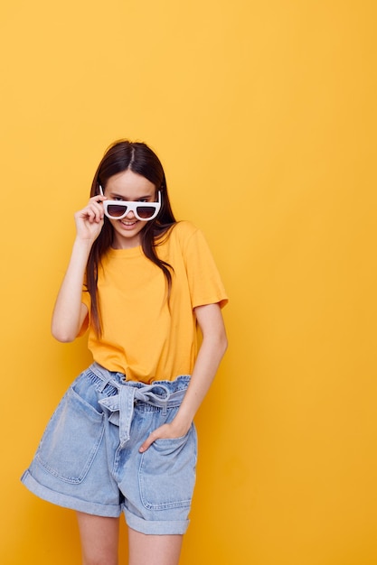 Foto chica guapa con el pelo largo con gafas de sol posando fondo aislado