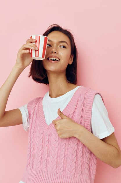 Foto chica guapa vaso de bebida desechable en una camiseta rosa fondo rosa