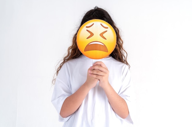 Foto de una chica triste, linda, triste, desesperada, expresando su condición interna con emoji