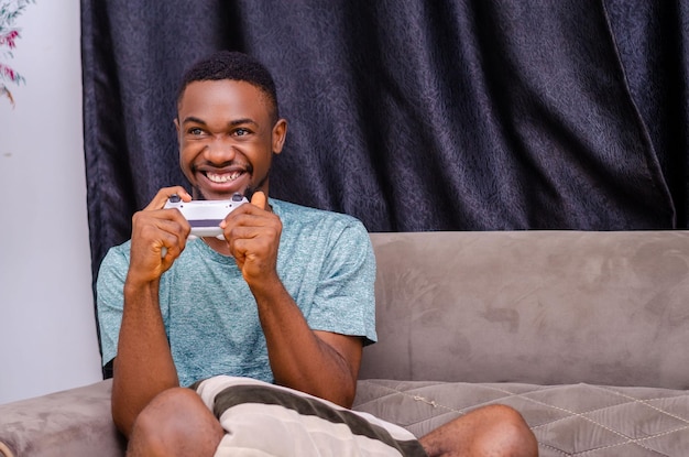 Foto de un chico guapo doméstico que se relaja en casa en cuarentena jugando videojuegos playstation football