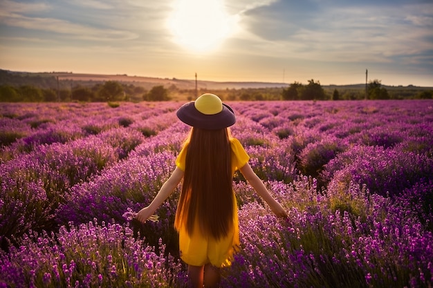 Foto de color brillante de una muchacha en la puesta del sol.