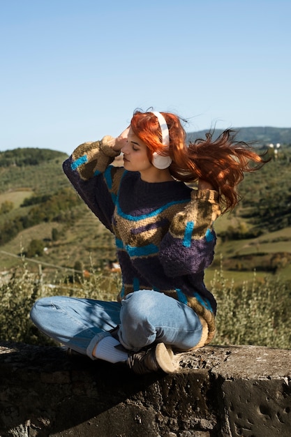 Foto foto completa de mulher usando fones de ouvido ao ar livre