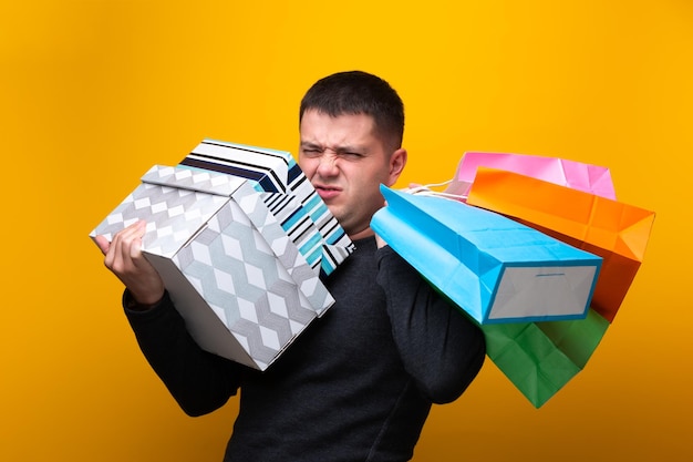 Foto de un comprador masculino con bolsas de papel y cajas.