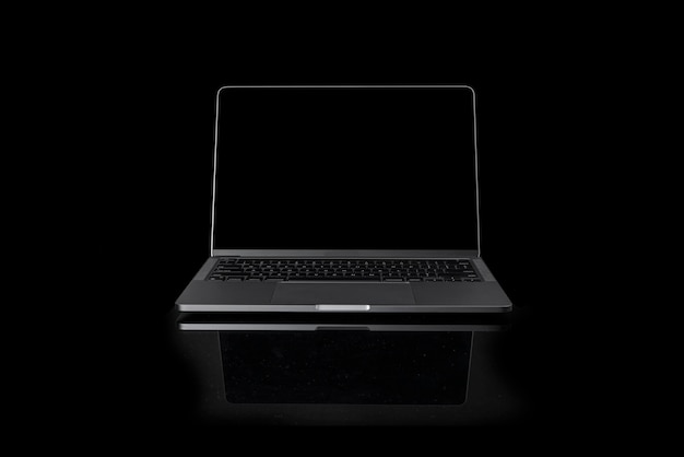 Foto de una computadora portátil moderna realista con pantalla en blanco frente a un fondo negro oscuro