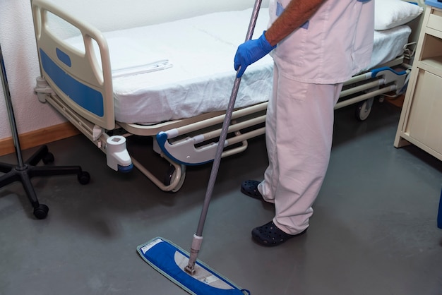 Foto conceitual de um funcionário de hospital limpando o quarto de um paciente