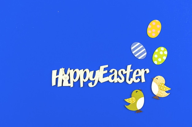 Foto de concepto de tarjeta de vacaciones de Pascua feliz en un fundamento azul y mensaje de texto