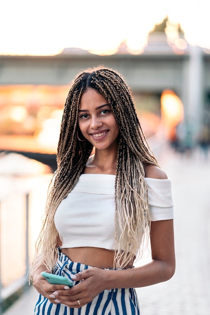 Foto conservada em estoque da jovem mulher afro-americana, sorrindo e olhando para a câmera.