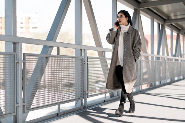 Foto conservada em estoque de uma jovem mulher de negócios, conversando ao telefone. Ela está sorrindo