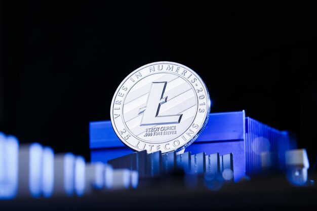 Foto de cripto moneda litecoin y procesador sobre fondo azul y negro