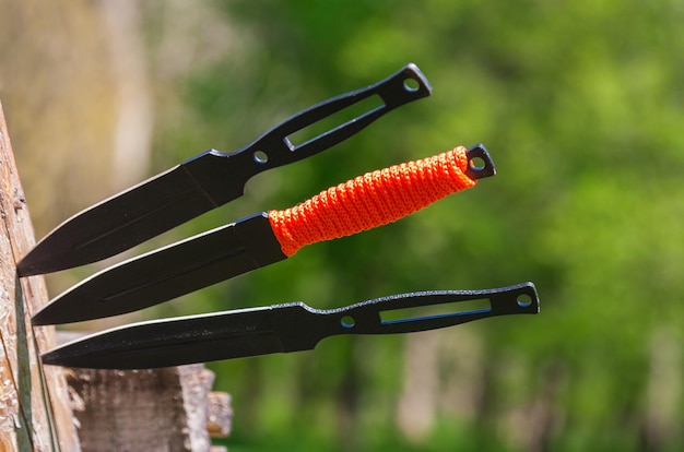 Foto de un cuchillo arrojadizo sobre un fondo de madera Cuchillo de acero inoxidable