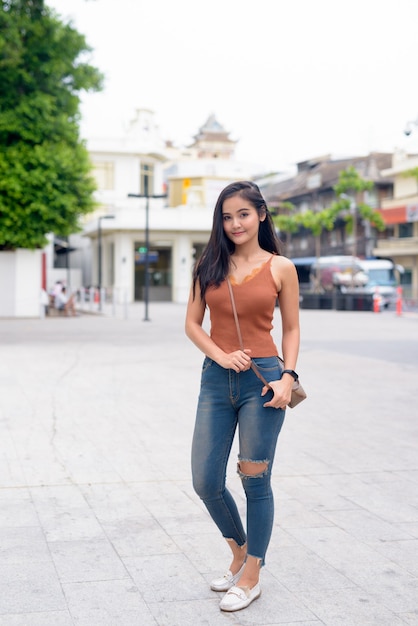 Foto de cuerpo completo de joven bella mujer asiática en las calles al aire libre