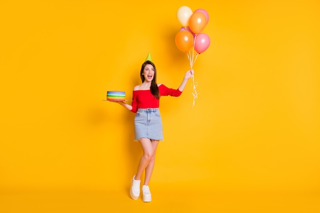 Foto de cuerpo entero de una chica alegre positiva que disfruta de la ocasión de la fiesta de aniversario.