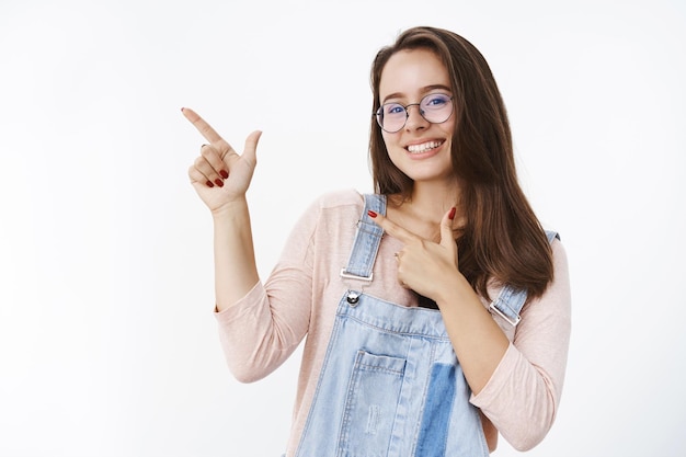 Foto da cintura de uma mulher feminina bonita e agradável usando óculos prescritos se sentindo feliz e encantada