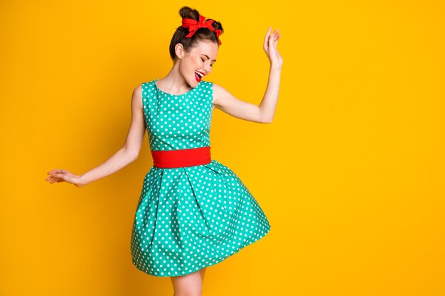 Foto da dança positiva da menina com saia azul-petróleo isolada sobre fundo de cor vívida