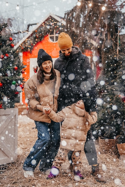 Foto da família estilosa mamãe papai filha nas costas feliz sorriso positivo se olham férias de inverno ao ar livre