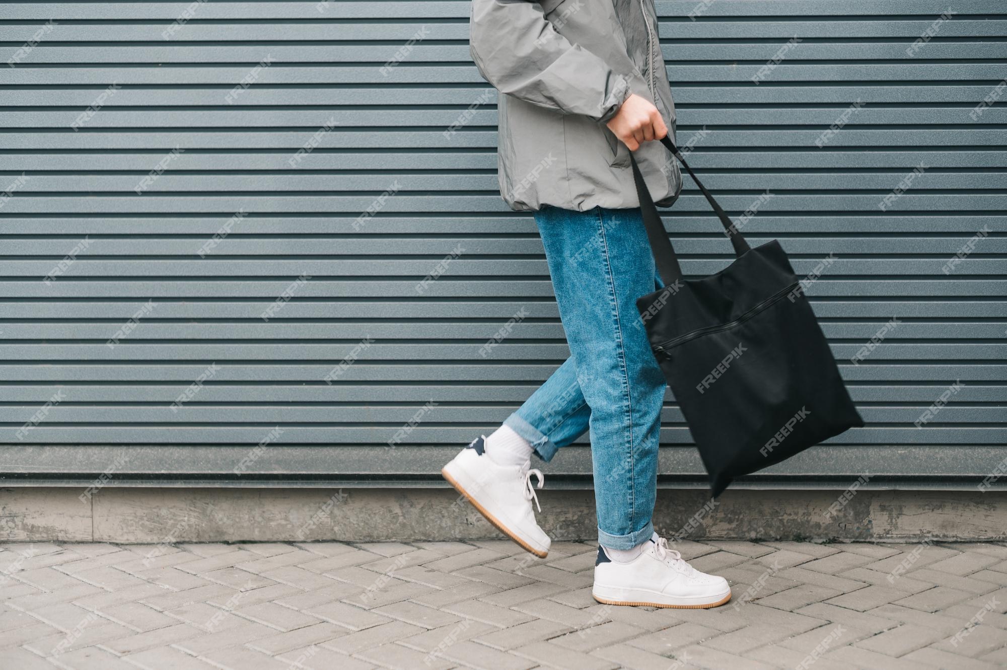 Foto da parte inferior de um jovem em roupas elegantes andando no