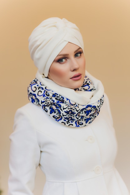 Foto da senhora árabe confiante em hijab, mostra o caminho certo, aponta para o espaço em branco com os dois dedos da frente, convida para ir para lá, promove o espaço da cópia. Confira comigo.