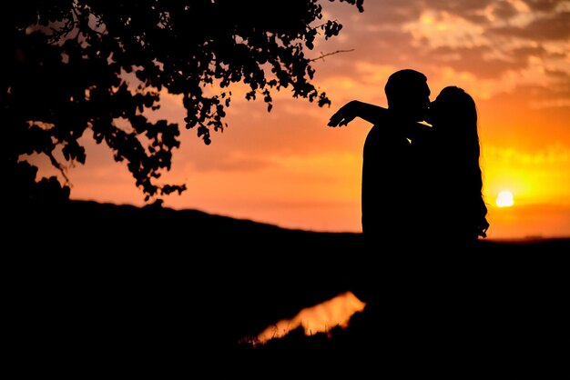 Foto foto da silhueta de um casal ao pôr do sol