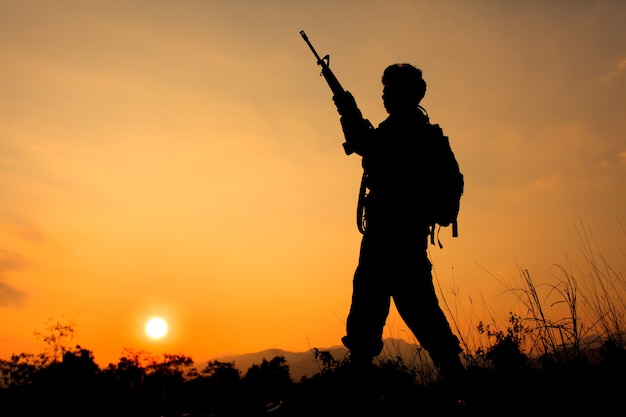 Foto da silhueta de um soldado segurando uma arma