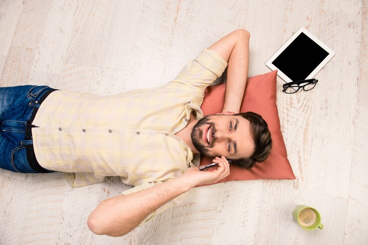 Foto foto da vista superior de um homem deitado no chão falando ao telefone