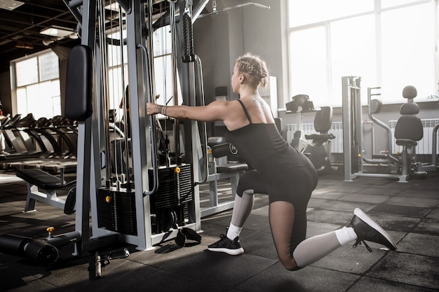 Foto da vista traseira de uma mulher que faz exercícios no estúdio de esportes