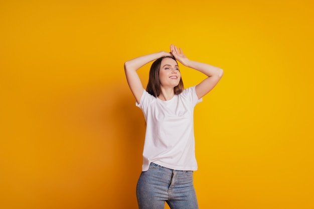 Foto de dama bastante soñadora mirar espacio vacío usar camiseta blanca posando sobre fondo amarillo