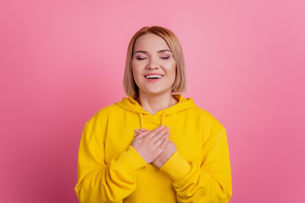 Foto de dama encantadora inspirada manos tocan el pecho corazón usar camiseta blanca aislada sobre fondo rosa