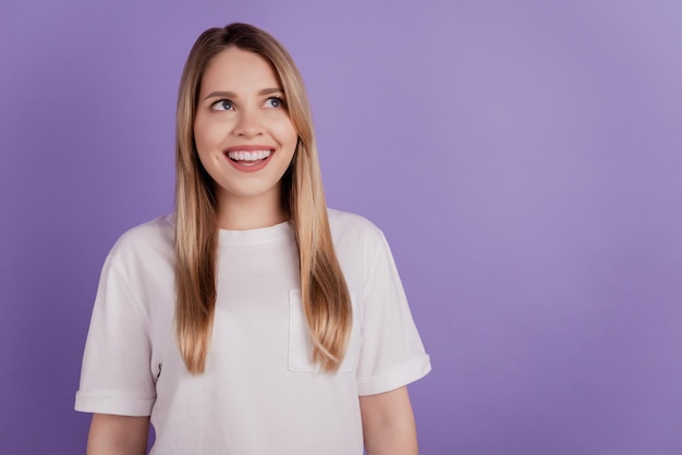 Foto de dama interesada positiva mirar espacio vacío sueño usar ropa casual sobre fondo violeta