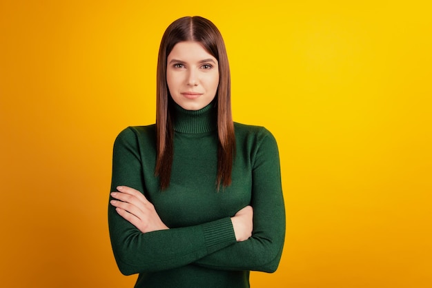 Foto de dama de negocios encantadora segura de sí misma con las manos cruzadas vistiendo camisa verde aislado sobre fondo amarillo