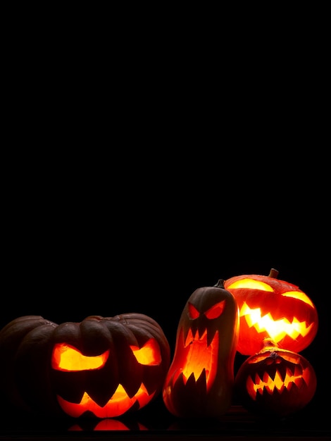 Foto de abóboras de halloween com bocas em chamas em fundo preto vazio em estúdio