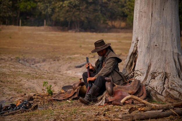 Foto de ação vintage de um caubói em um campo ao sol suave da manhã