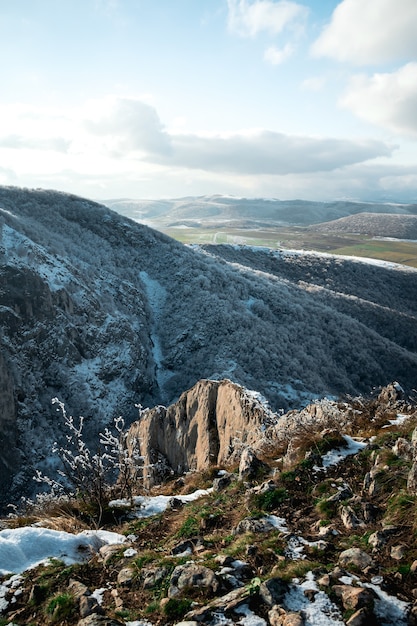 Foto de alto ângulo das altas montanhas cobertas com pouca neve durante o dia