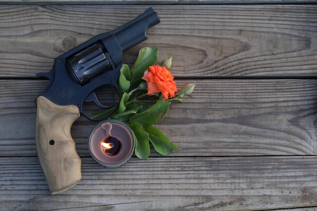 Foto foto de arte. natureza morta vintage com arma e rosa em fundo de madeira