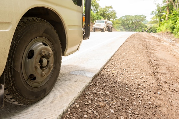 Foto de baixo ângulo de um microônibus estacionado em uma estrada de concreto hidráulico na Nicarágua