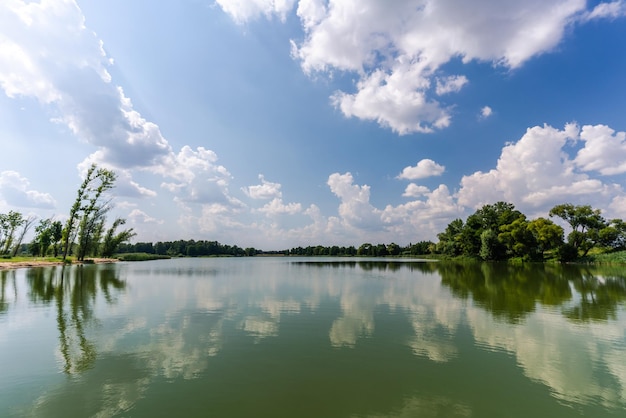 Foto de baixo ângulo do lindo céu capturado de um lago em um campo