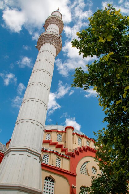 Foto foto de baixo do céu nublado azul e do minarete da mesquita