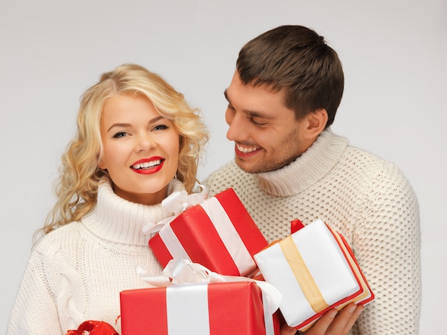 foto de casal de família em um suéter com caixas de presente