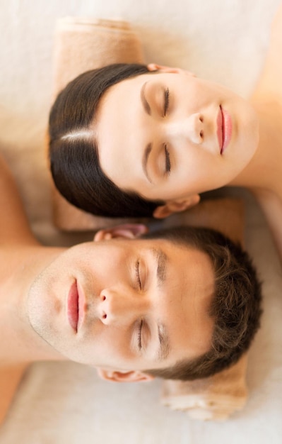 foto de casal em salão de spa, deitado nas mesas de massagem