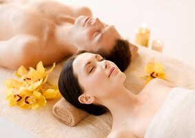 Foto foto de casal em salão de spa, deitado nas mesas de massagem