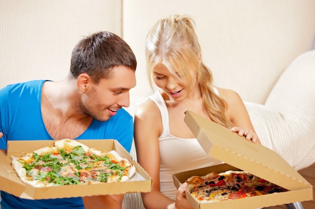 foto de casal romântico feliz comendo pizza em casa (foco no homem)